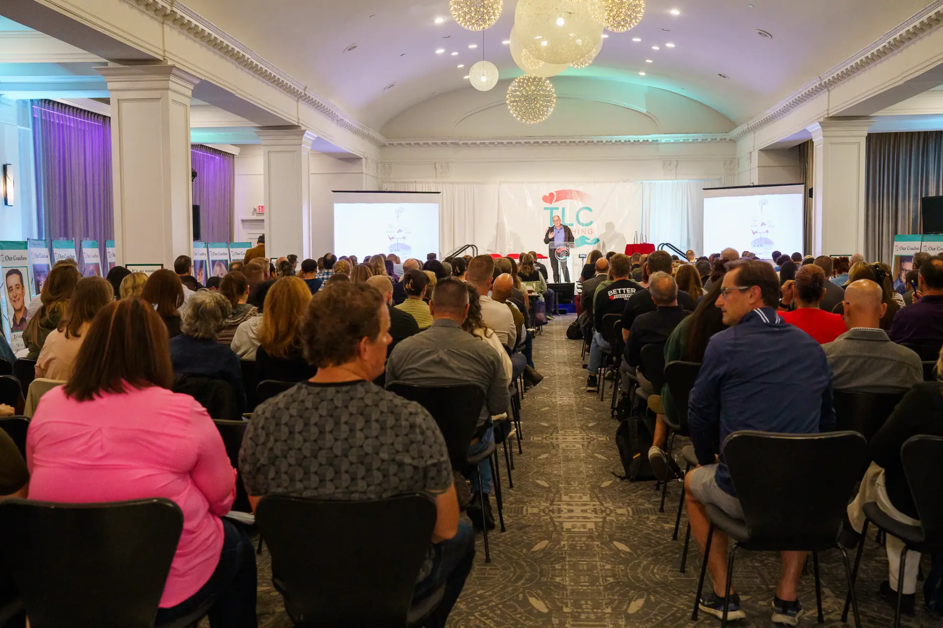 A packed TLC seminar ballroom facing the stage