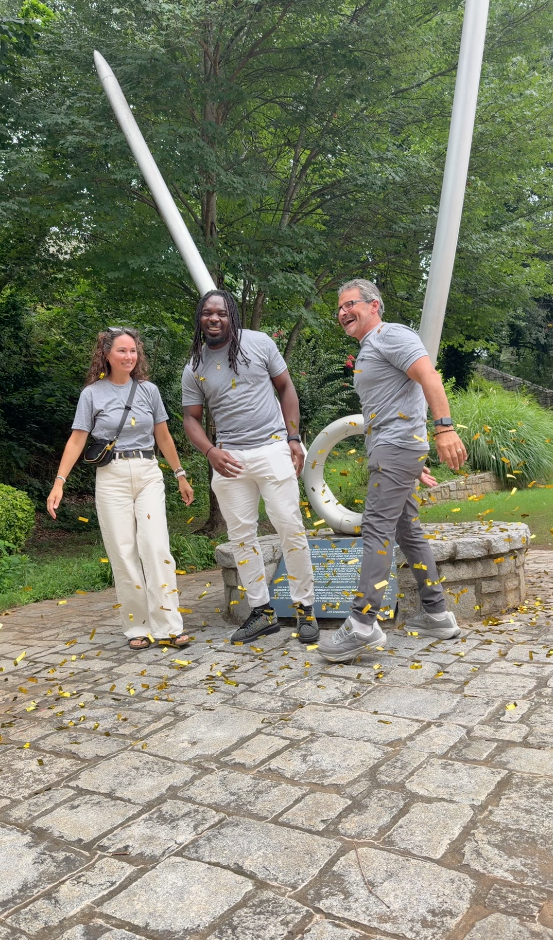 Three TLC members laughing in a shower of confetti on campus