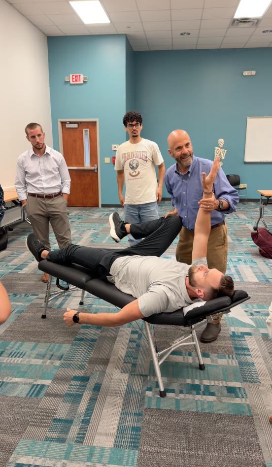 A portable adjusting table demonstration with students watching