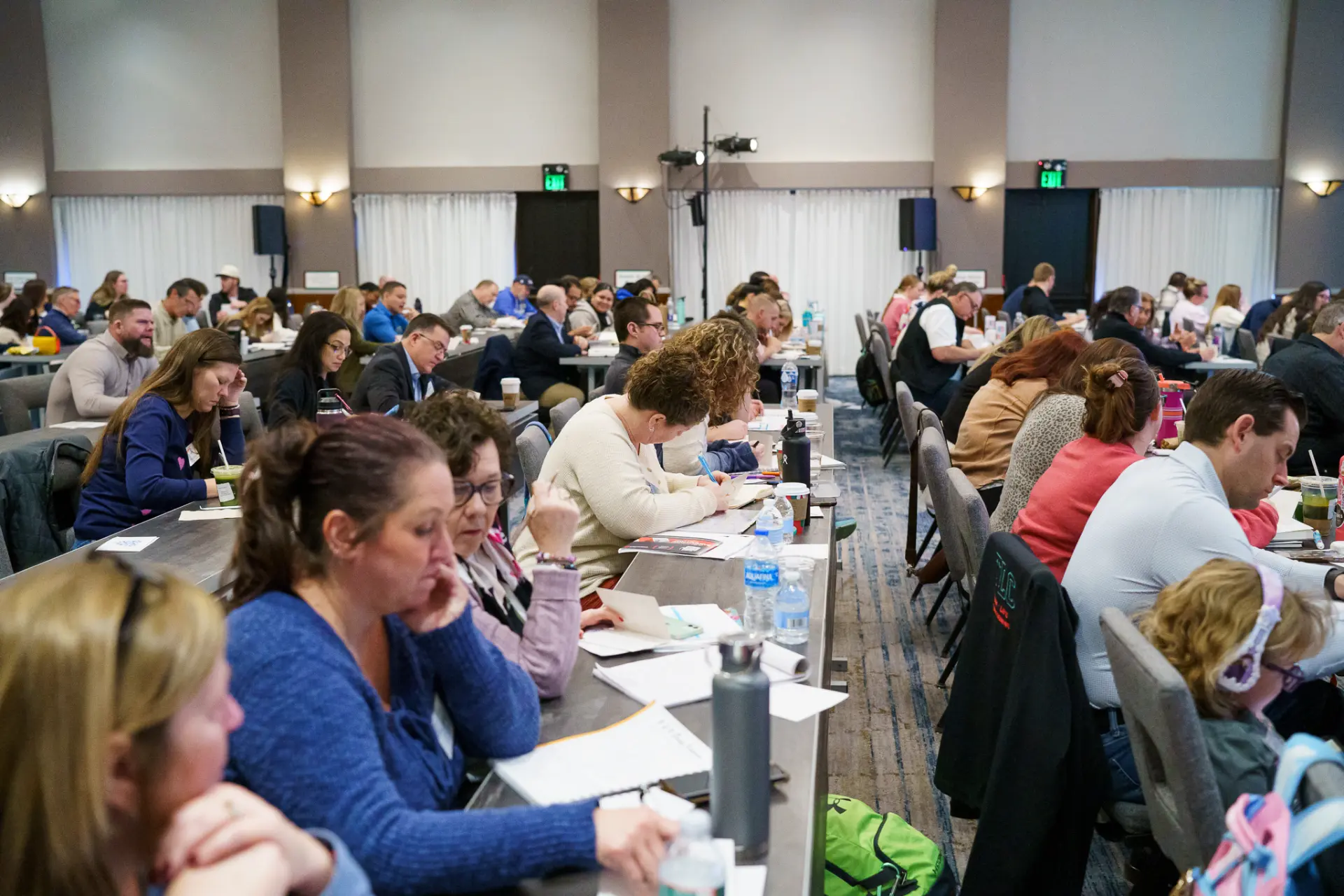 A full room of TLC members taking notes during a seminar