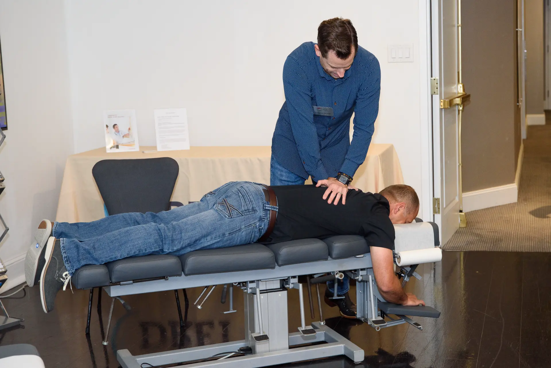 A chiropractic adjustment demonstration on a table at a TLC event